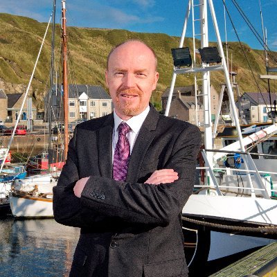 Photo of Eann Sinclair in front of Wick Harbour.
